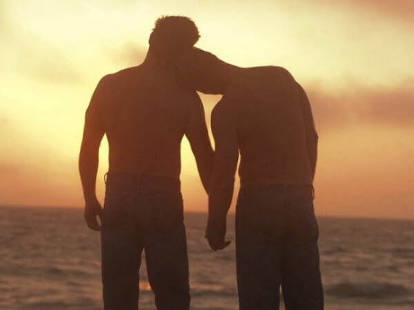 Ecco perchè comprare preservativi online è più conveniente - coppia gay romantica in spiaggia 1 - Gay.it