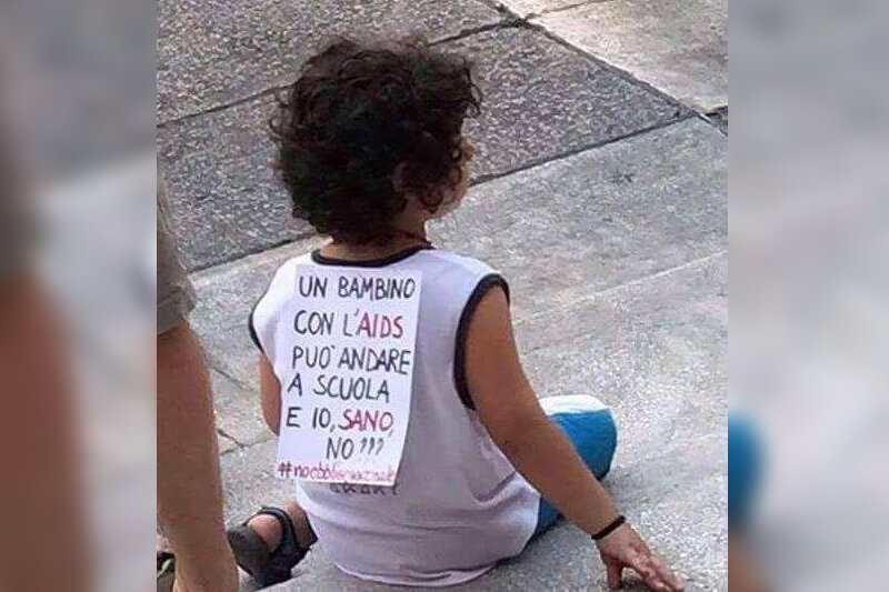 Genitori no-vax attaccano al figlio il cartello "Un bambino con l'AIDS può andare a scuola e io no?" - Gay.it