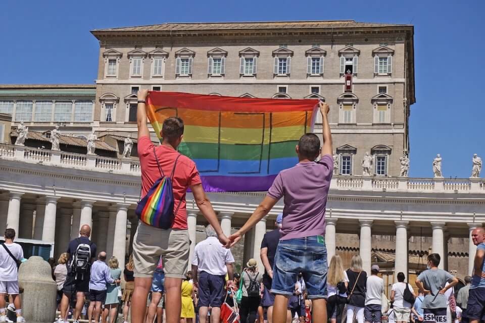 DDL Zan, perché le aggravanti sono ostacolo alla libertà di culto solo quando riguardano le persone LGBT? - Coppia gay con la bandiera rainbow allAngelus in Vaticano - Gay.it
