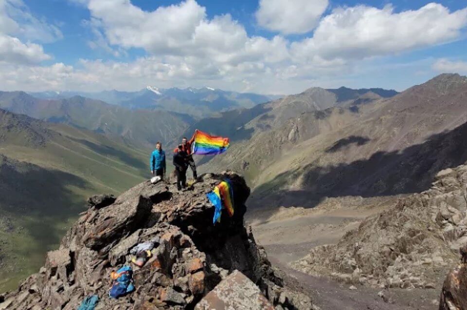 Scalatori gay issano bandiera rainbow sulla cima della montagna di Vladimir Putin