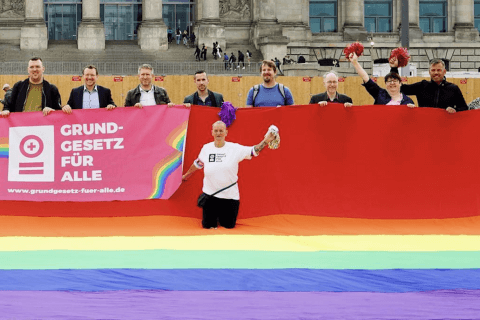 Germania, attivisti LGBTQIA+ chiedono modifica costituzionale a protezione delle persone queer - Germania bandierone rainbow davanti il Parlamento per chiedere protezione costituzionale per le persone queer - Gay.it