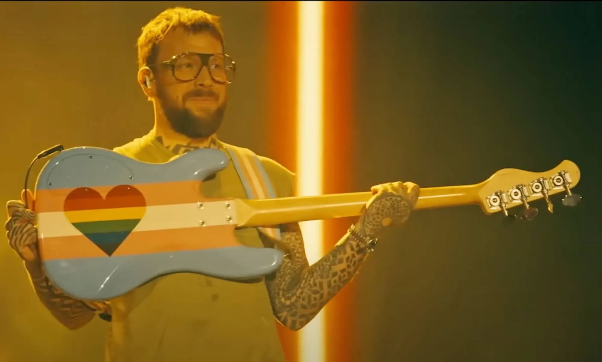 Gli Imagine Dragons dichiarano i loro concerti “spazio sicuro per le persone LGBTQIA+" - Imagine Dragons Ben McKee trans flag guitar - Gay.it