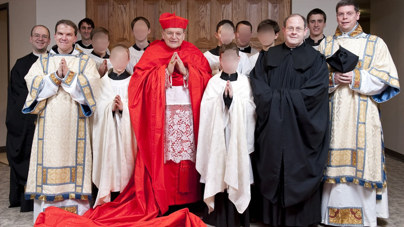 Il Cardinale Raymond Leo Burke circondato da giovani preti e angelici chierichetti.