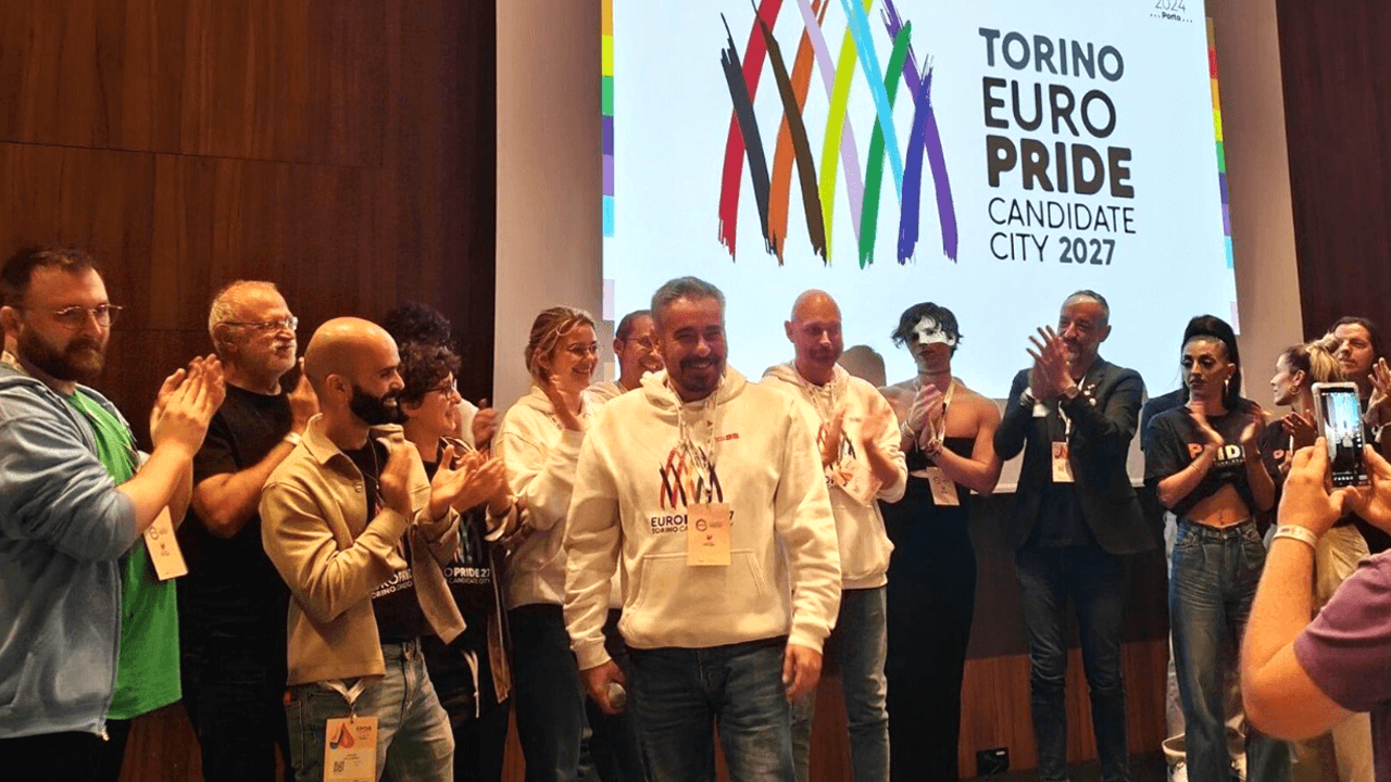 Alesandro Battaglia (al centro) insieme ad alcunə attivistə del comitato organizzatore del Torino EuroPride 2027 sul palco del Lovers Film Festival 2026